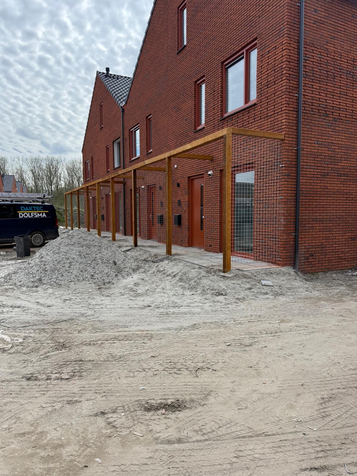 Hardhouten pergolaconstructies met metalen gaaspanelen voor beplanting, als onderdeel van 1.300 meter pergola’s in een nieuwbouwwijk in Delfzijl.